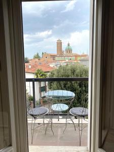 Habitación con vistas a un balcón con mesa y sillas. en Vista Duomo Ravenna Apartment, en Rávena