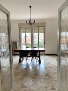 a dining room with a table and chairs and windows at Vista Duomo Ravenna Apartment in Ravenna