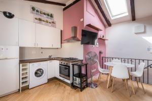 a kitchen with a table and a sink and a washing machine at Appartamento al Pratello nel cuore pulsante della citta' in Bologna
