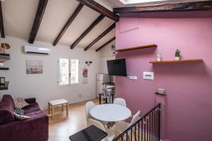 a living room with a pink wall and a table at Appartamento al Pratello nel cuore pulsante della citta' in Bologna