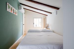 two beds in a white room with a window at Appartamento al Pratello nel cuore pulsante della citta' in Bologna