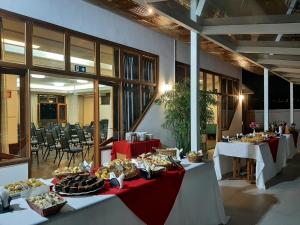 a group of tables with food on them in a building at Serrano Residencial Hotel in Juiz de Fora