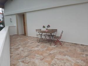 a room with a table and chairs and a white wall at Apartamentos San Juan in Arnuero
