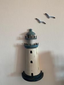 リド・マリーニにあるCasa Bianca & BLU a due passi dal mareの鳥が二羽飛ぶ灯台模型