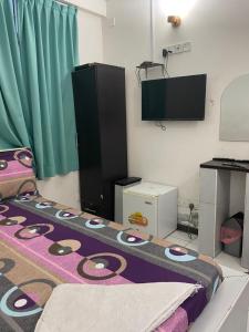 a room with a bed and a flat screen tv at REYALI GUEST HOUSE in Male City