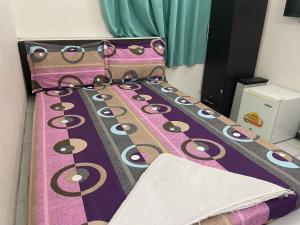 a bed with a purple bedspread with eyes on it at REYALI GUEST HOUSE in Male City