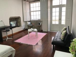 ein Wohnzimmer mit einem Sofa und einem Tisch in der Unterkunft Casa da Maria in Ponte de Lima