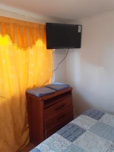a bedroom with a bed and a tv on the wall at Tifrys in La Serena
