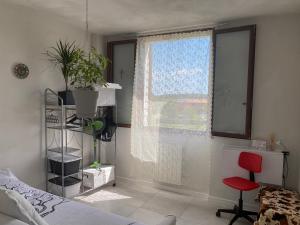 a bedroom with a bed and a window with a red chair at Camera Monica in Peschiera del Garda