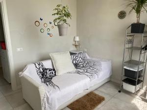 un sofá blanco en una habitación con una planta en la pared en Camera Monica, en Peschiera del Garda