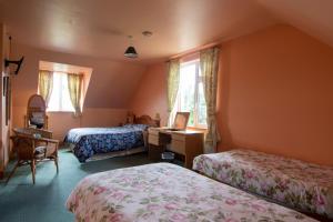 a bedroom with two beds and a desk with a computer at Ferryview B&B in Cahersiveen