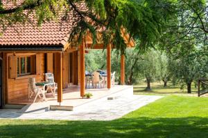 eine Veranda eines Hauses mit einem Tisch und Stühlen in der Unterkunft Villa degli Ulivi in Lempa