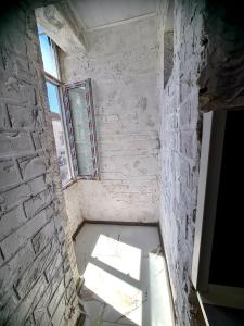 une pièce vide avec une fenêtre et un mur en briques dans l'établissement Топ Център едностаен!, à Razgrad