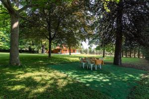a table and chairs in a park with trees at Villa degli Ulivi in Lempa