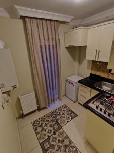 安卡拉的住宿－CONCEPT HoUSE，小厨房配有白色橱柜和炉灶。