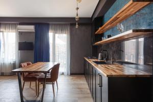 kuchnia z drewnianym stołem i jadalnią w obiekcie Irina's Apartments w Kutaisi