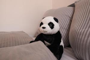 a stuffed panda bear sitting on a couch at FULL HOUSE Studios - Panda Apartment - WiFi inkl in Halle an der Saale