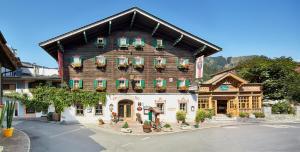 a large wooden building with flowers on the windows at Romantikhotel Zell am See in Zell am See