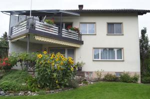 a house with a balcony and sunflowers at Ferienwohnung Beate in Höchst