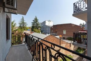 balkon z czarną poręczą i budynek w obiekcie Irina's Apartments w Kutaisi