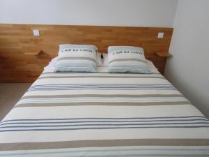 Una cama con dos almohadas encima. en Chambre d'hôte, Royan plage, petit-déjeuner bio, en Royan