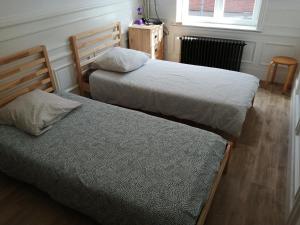a bedroom with two beds and a window at Bruneval lodge in Dunkerque