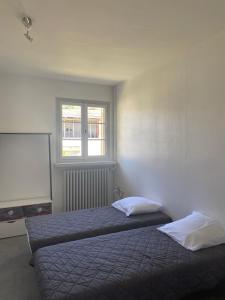 um quarto com 2 camas e uma janela em Les roses de l'Olivier em Les Rosiers