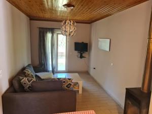 a living room with a couch and a chandelier at SPITI MAGDALINI in Agios Georgios Pagon