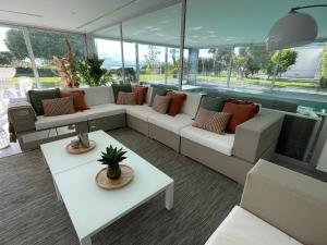 a living room with couches and tables and windows at Casa Llosa in Roses