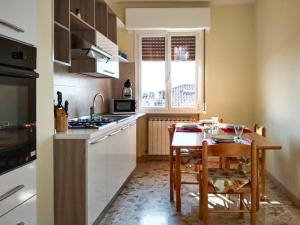 een keuken met een kleine tafel en een keuken met witte kasten bij Casa Bignardi - Affitti Brevi Italia in Modena
