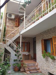 ein Backsteinhaus mit einer Treppe und einem Balkon in der Unterkunft Jordhani's House in Korçë
