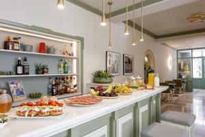 a breakfast bar with plates of food on a counter at Mythos Suites Boutique Hotel in Rethymno Town