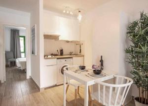 a white kitchen with a table and chairs in a room at Holyhome premium 105 in Costa Teguise