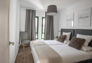 a bedroom with a large bed and a chair at Holyhome Premium 106 in Costa Teguise