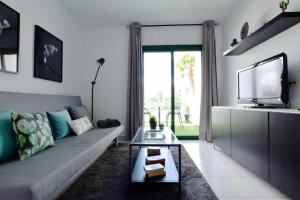 uma sala de estar com um sofá e uma televisão em Holyhome apartment 204 em Costa Teguise