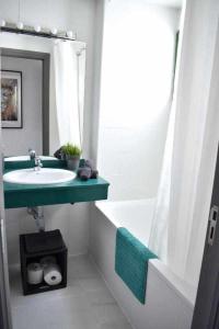 uma casa de banho com um lavatório, uma banheira e um espelho. em Holyhome apartment 204 em Costa Teguise