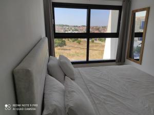 a bed in a room with a large window at Sunset kallithea in Kallithea Halkidikis