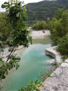 una piscina de agua azul en un río en Chambre campagnarde, en Roquestéron