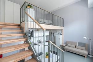 Vorgarten Apartments - central, new and stylish for your comfortable stay in Vienna في فيينا: درج حلزوني في غرفة المعيشة مع أريكة