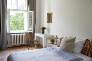 Schlafzimmer mit einem Bett, einem Tisch und einem Fenster in der Unterkunft Schloss Mörlbach in Mörlbach