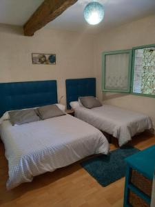 1 dormitorio con 2 camas y ventana en Gîte de La Brenelière en Cirière