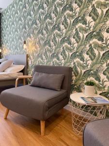 Vento Suites في كالياري: غرفة معيشة مع أريكة وورق جدران