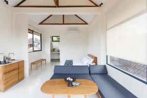 ein Wohnzimmer mit einem blauen Sofa und einem Tisch in der Unterkunft Contemporary Artisanal Studio Apartment in Ubud in Ubud