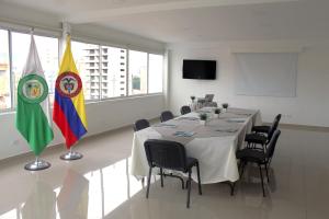 a conference room with a table and two flags at Hotel Suite Comfort in Medellín