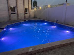 a large pool with blue water with lights on it at Al Noor Plaza in Salalah