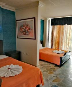 a hotel room with two beds with orange sheets at HOTEL YORYTANIA BOUTIQUE in Pitalito +89 photos
