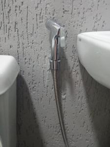 a hose is attached to a sink in a bathroom at Conjugado Aconchegante em Teresópolis in Teresópolis