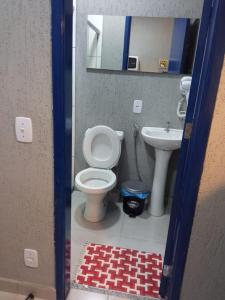 a bathroom with a toilet and a sink at Conjugado Aconchegante em Teresópolis in Teresópolis