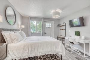 a white bedroom with a bed and a desk at Lighthouse Kitchen Suites near Auburn Waterloo I-69 Exit 334 in Auburn