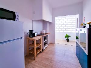een keuken met een witte koelkast en een houten vloer bij FLH Loulé Balcony Spacious Apartment in Loulé